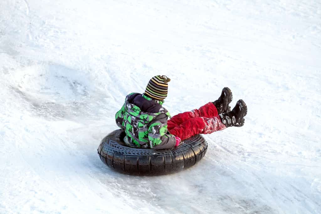 Child on a snowtube in the snow.