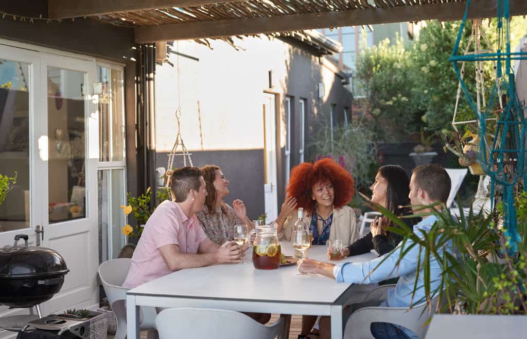 Group enjoying wine around a vacation rental outdoor patio table