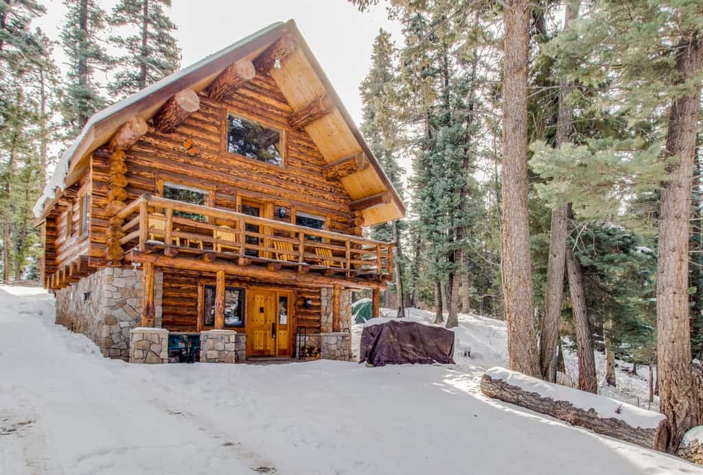the snowy exterior of a log cabin in Durango, CO