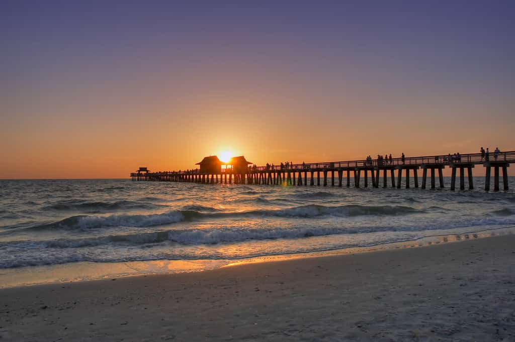 the sun setting over the ocean in Naples, Florida