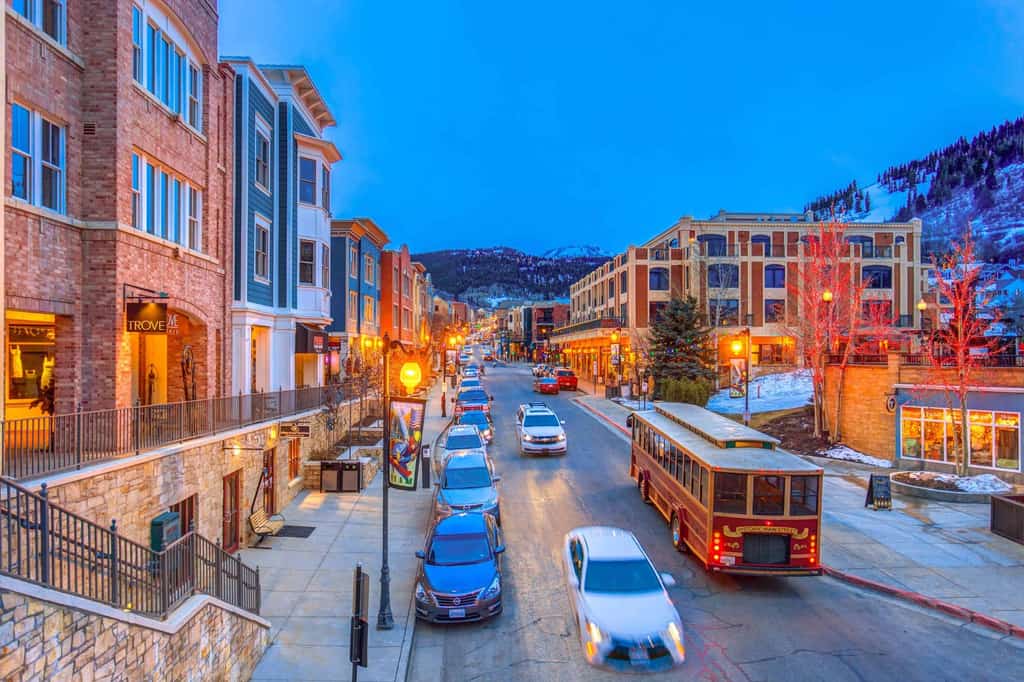 Busy street with cars in Park City and snow in the mountains