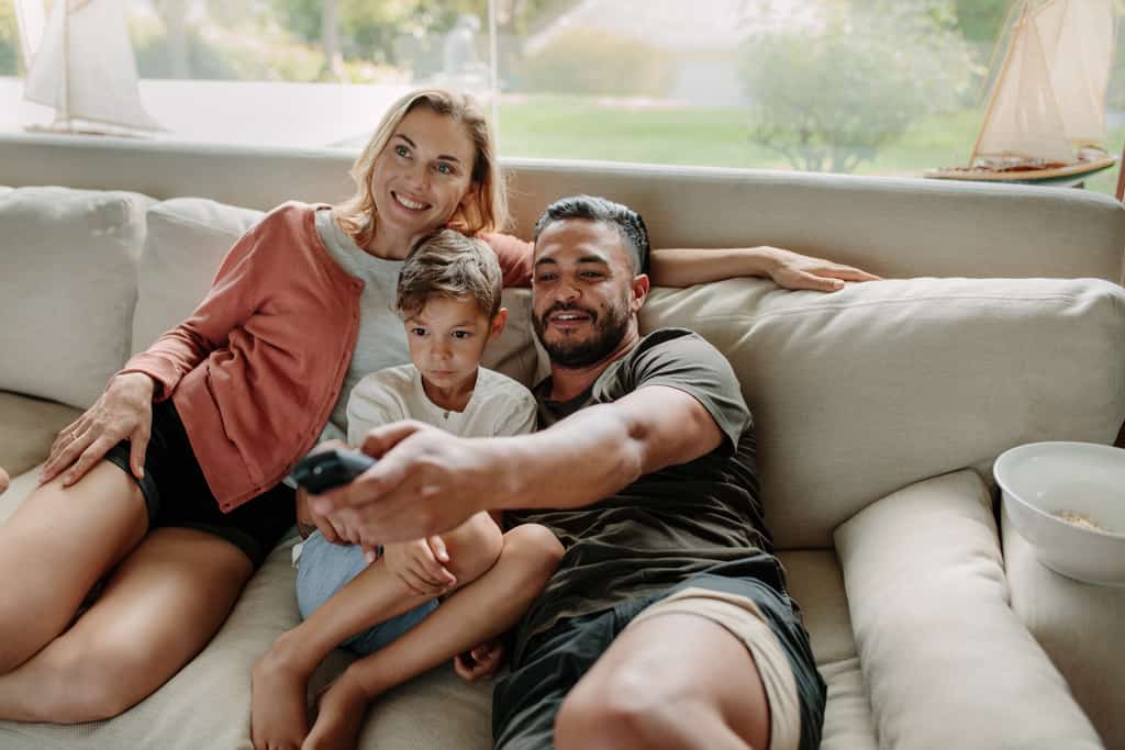 family sitting on couch watching TV