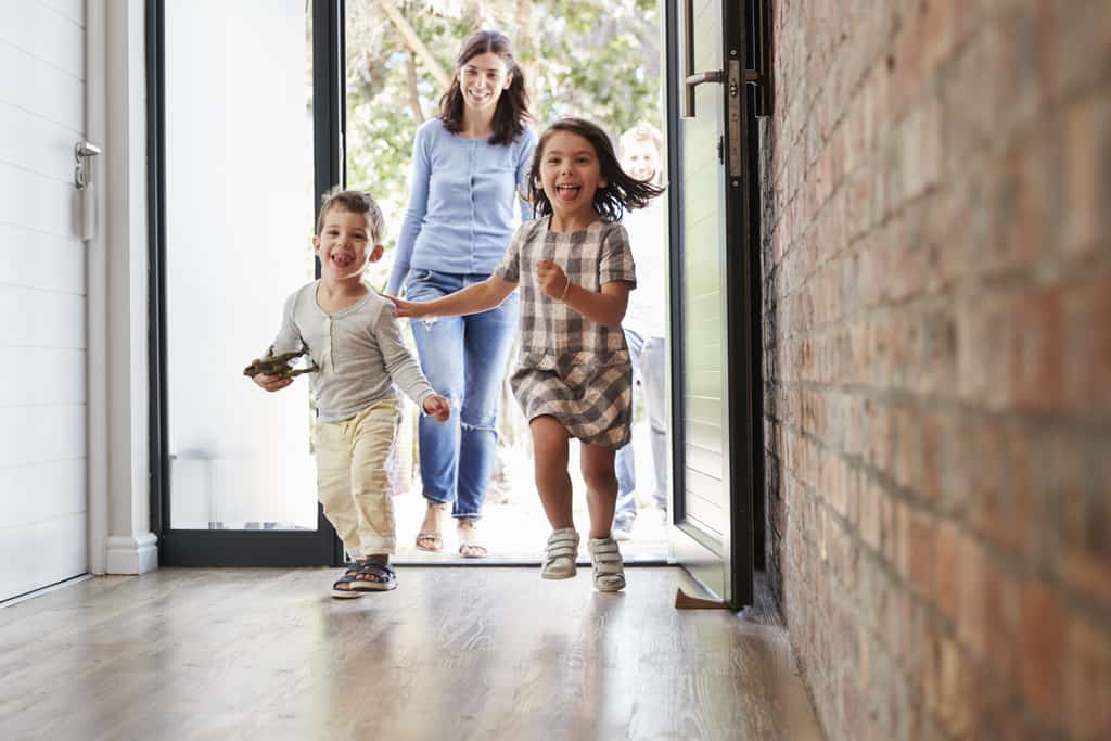 Woman with two children enter vacation home