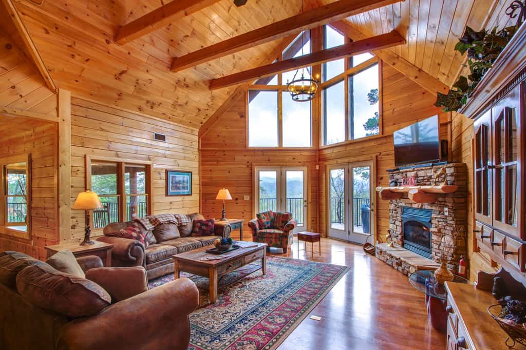 Gas fireplace, floor-to-ceiling windows and wood paneling create a cozy atmosphere at this vacation cabin