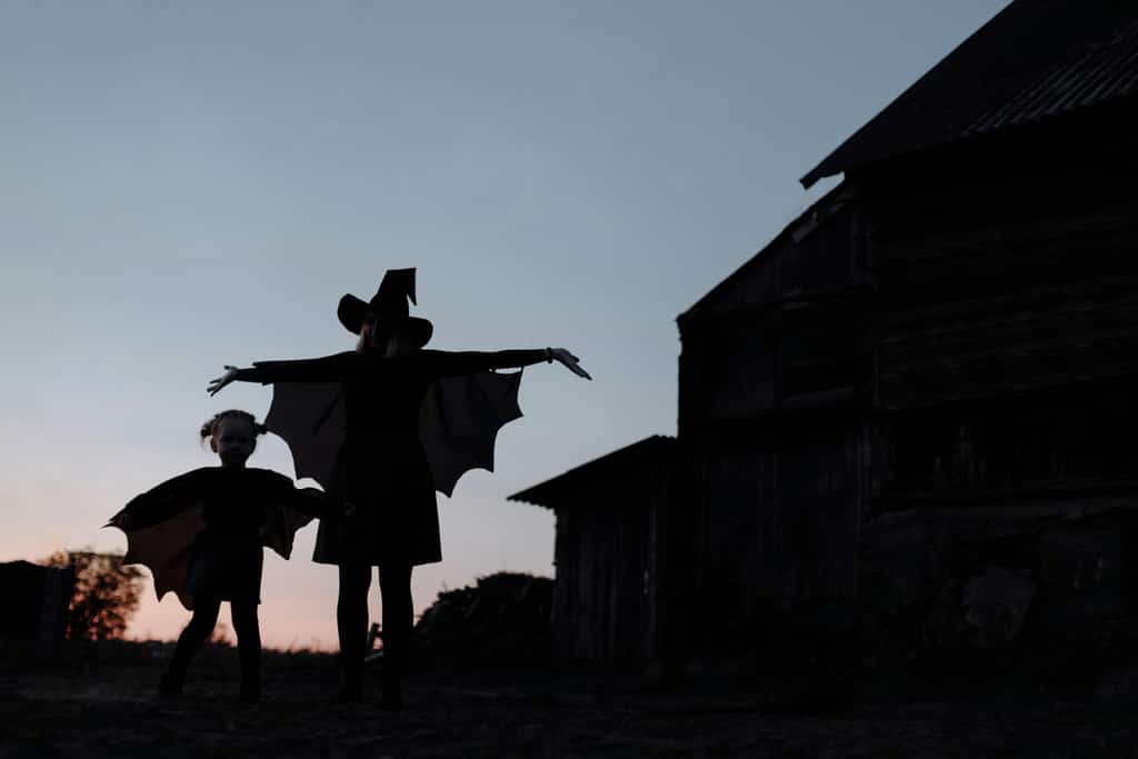 A woman with a child dressed as witches.