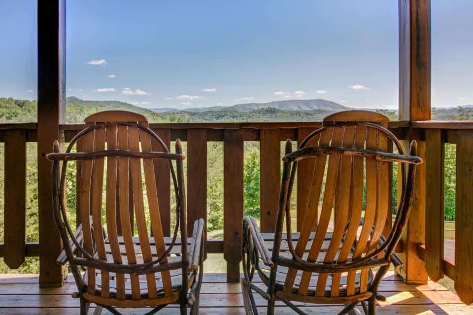 Two rocking chairs on a deck facing the Smoky Mountains