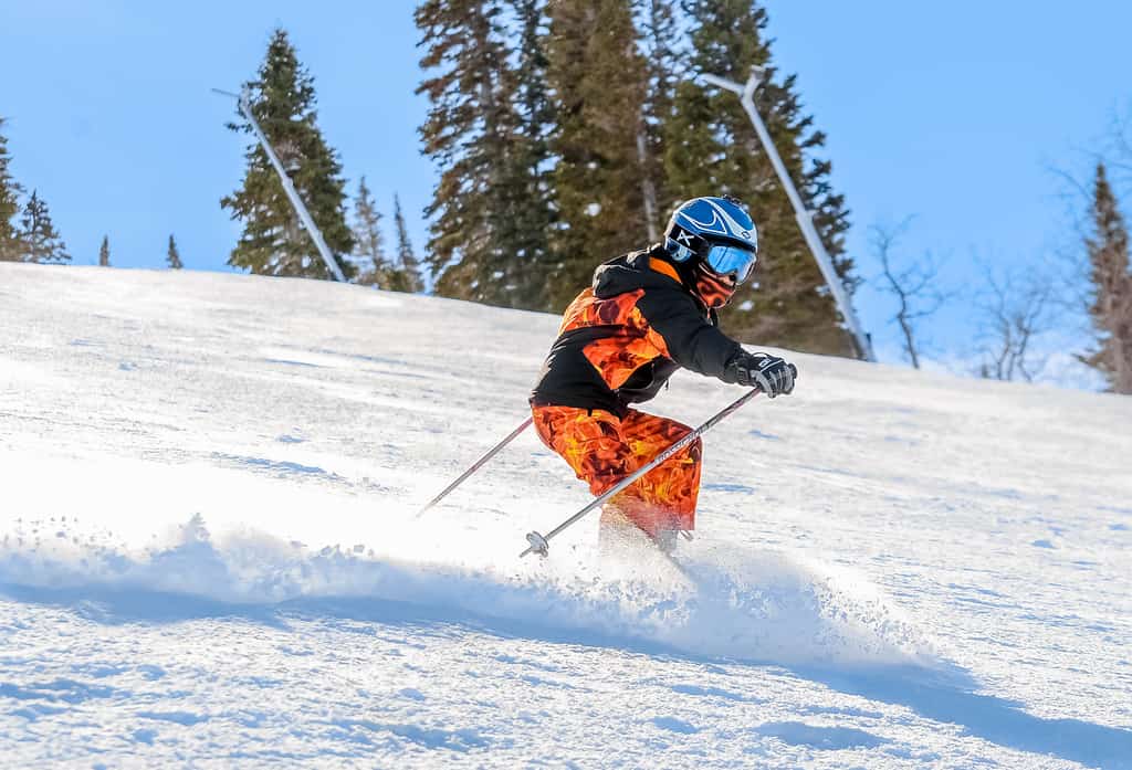 a skier wearing an orange outfit going down the slopes at Park City